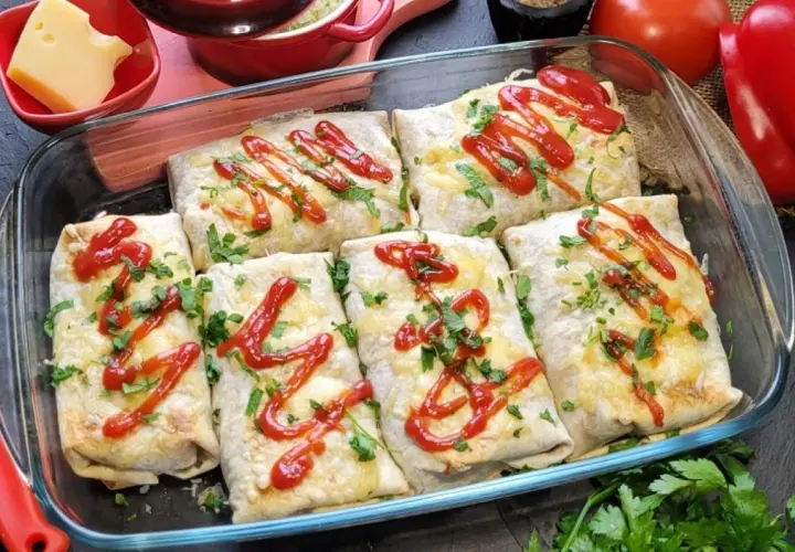 Zapiekana tortilla z mięsem mielonym, serem i ketchupem, posypana natką pietruszki, w szklanym naczyniu.