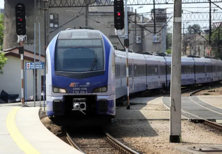 Niebiesko-biały pociąg PKP Intercity ED160-020b na torach, z sygnalizacją świetlną.