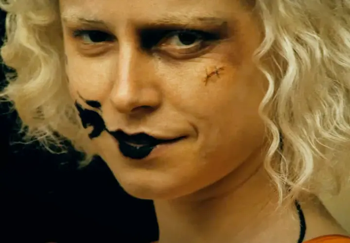 Blondynka z makijażem jak z nowych horrorów, czarne usta i blizna na policzku.