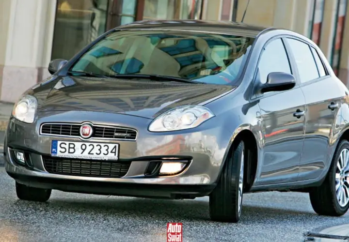 Szary Fiat Bravo 2 z tablicą rejestracyjną SB 92334 na tle budynku.