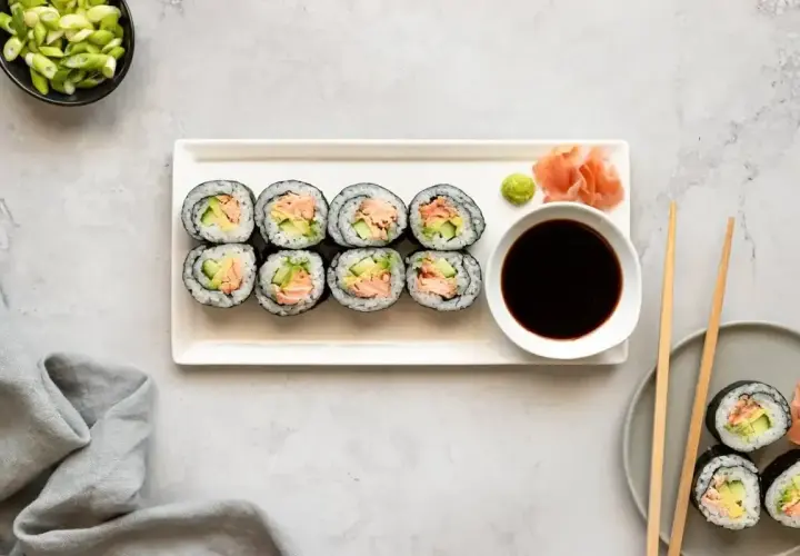 Smaczne hosomaki z łososiem i awokado, podane z sosem sojowym i wasabi.