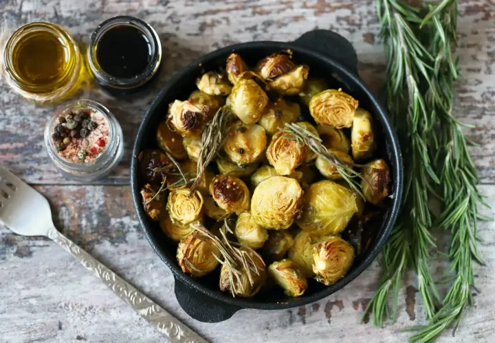 Cavoletti di Bruxelles arrostiti in padella con rosmarino, accompagnati da olio, aceto balsamico e sale aromatizzato.