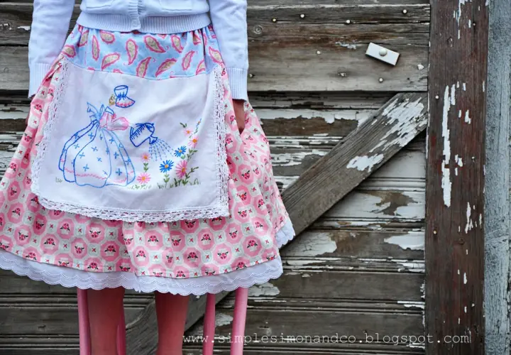 A vintage apron skirt pattern with a girl watering flowers, set against a rustic wooden background.