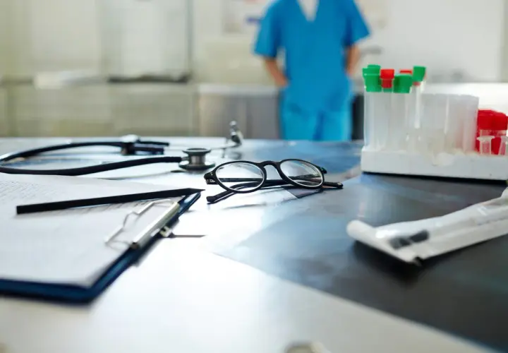 Occhiali, stetoscopio e provette su un tavolo. Il medico di base quanti pazienti ha oggi?
