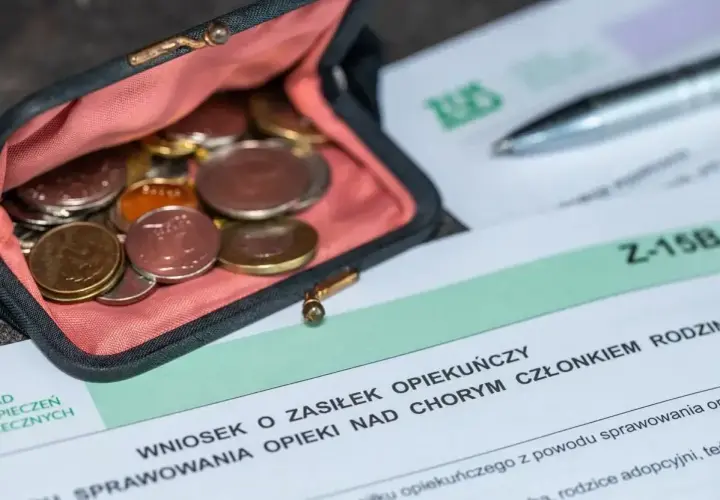 Portmonetka z monetami obok wniosku o zasiłek opiekuńczy.
