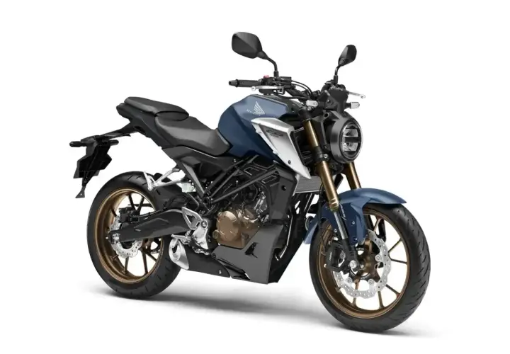 Niebieski motocykl Honda CB125R, jeden z najszybszych 125, z brązowymi felgami i okrągłym reflektorem.
