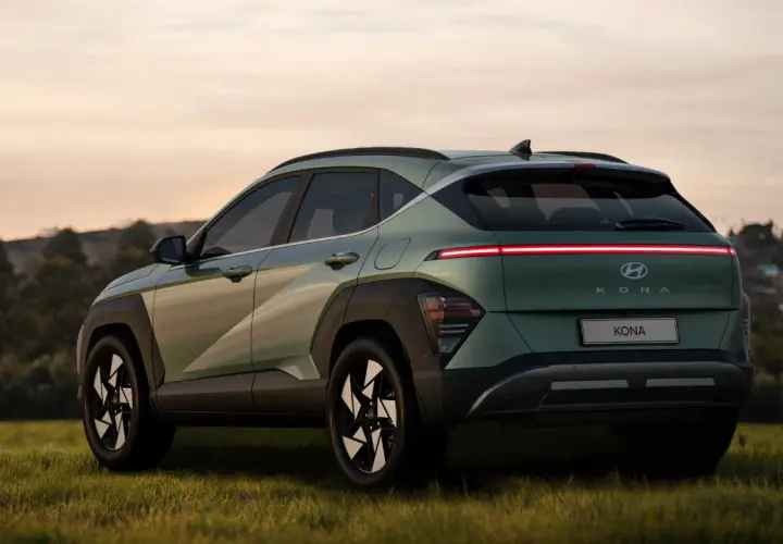 Nowy Hyundai Kona w zielonym kolorze, z charakterystycznym pasem świateł z tyłu. Sprawdź atrakcyjną hyundai kona cena.
