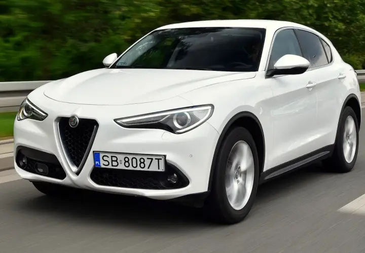 Białe Alfa Romeo Stelvio w ruchu. Kierowcy chwalą jego dynamikę, co potwierdzają liczne alfa romeo stelvio opinie.