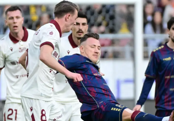 Piłkarze Pogoń Szczecin kontra Widzew Łódź. Zacięta walka o piłkę na boisku, emocje sięgają zenitu.