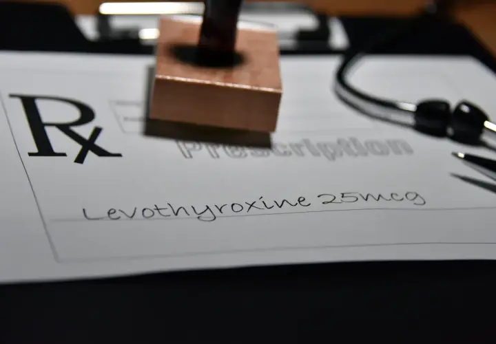 Recept na leki, na którym widnieje "Levothyroxine 25mcg". Obok stetoskop i pieczątka.