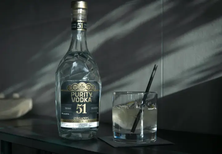 Butelka Purity Vodka i szklanka z drinkiem. Wódka, okowita i bimber – definicje prawne.