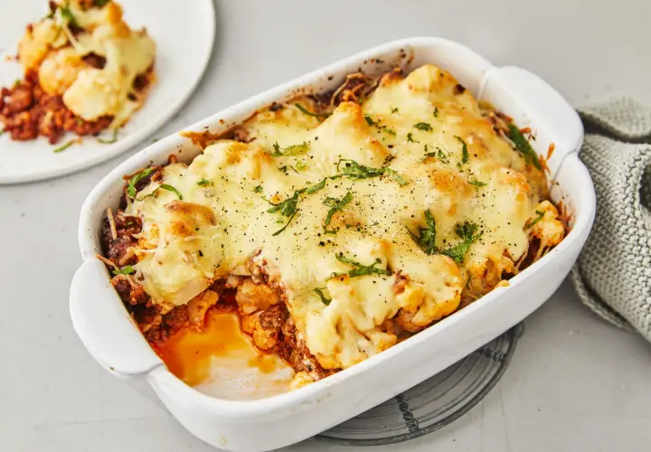 Herzhafter Blumenkohlauflauf mit Hackfleisch, überbacken mit geschmolzenem Käse und garniert mit frischen Kräutern. Ein köstliches Gericht, das Lust auf mehr macht.