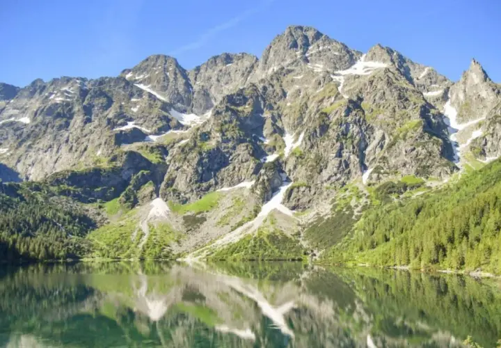 Majestatyczne Tatry odbijają się w tafli Morskiego Oka. Choć jego głębokość jest imponująca, to widok zapiera dech w piersiach.