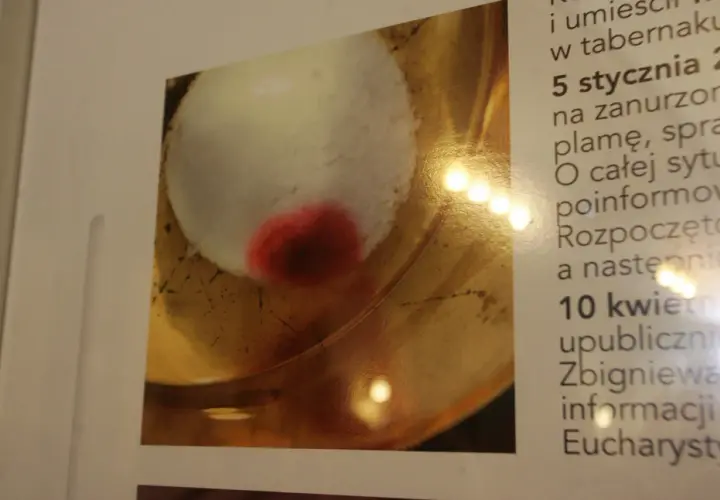 Hostia z czerwoną plamą, przypominająca cud. Tekst obok opisuje wydarzenia z 5 stycznia i 10 kwietnia, dotyczące informacji o Eucharystii.