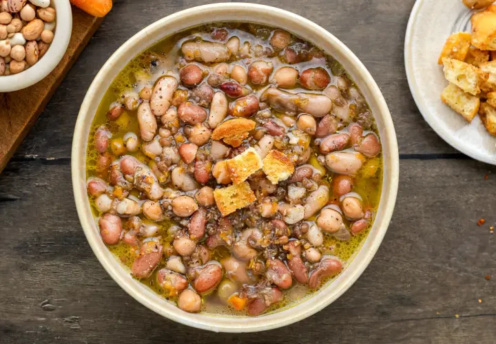 Una ciotola fumante di zuppa di legumi, ricca e saporita, con crostini dorati.