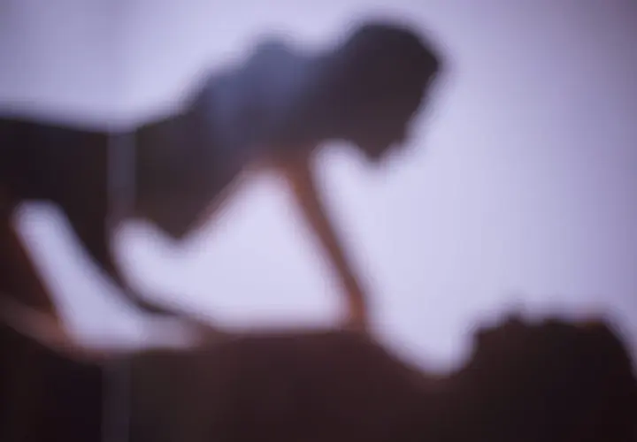 Ombre sfocate di due persone che si abbracciano, evocando la gioia e l'intimità della giornata mondiale dell'orgasmo.