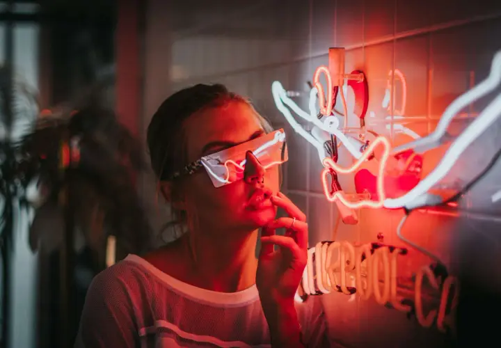 Dziewczyna w neonowych okularach przy świetlnej instalacji. Idealne miejsce, gdzie można potańczyć w Kołobrzegu, czeka na Ciebie!
