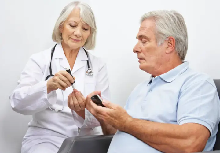 Diabetolog bada poziom cukru we krwi pacjenta.