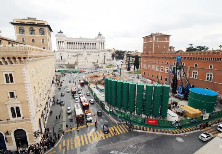 Vista aerea di Roma con il Vittoriano sullo sfondo e lavori in corso. Per capire come arrivare a Piazza Venezia, osserva il traffico e i palazzi storici.