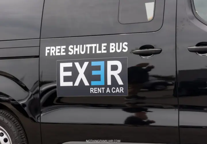 Black shuttle bus with "EXER RENT A CAR" logo. Considering whether to rent a car in Athens? This shuttle might be a good option.