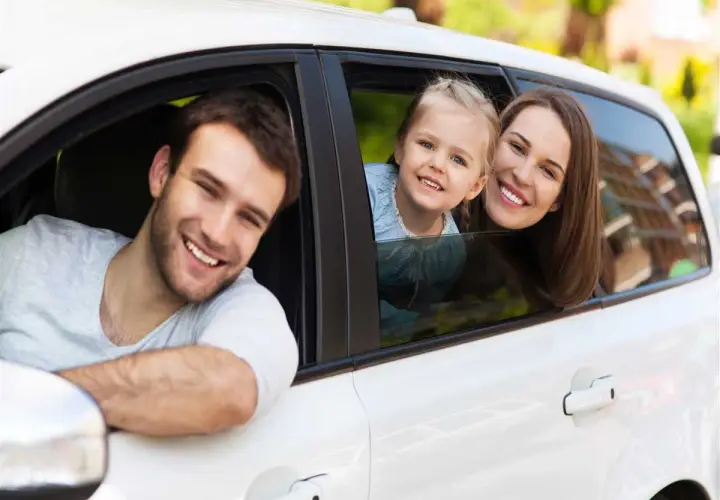 Famiglia sorridente in auto. Pensano al passaggio di proprietà tra familiari costo per un nuovo veicolo.