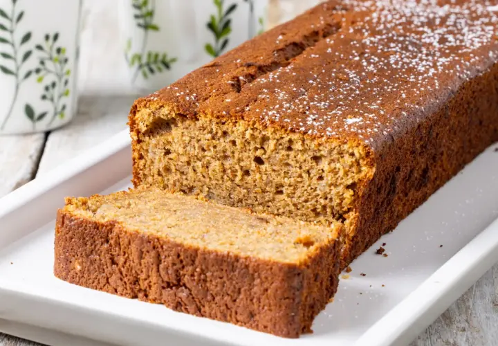 Fetta di banana bread light, soffice e dorata, cosparsa di zucchero a velo. Perfetta per una colazione sana.