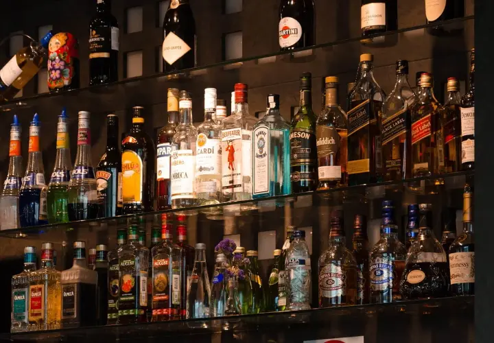 Na półkach barowych stoją butelki alkoholi, w tym kilka butelek tequili, idealnych do przygotowania pysznej margarity.