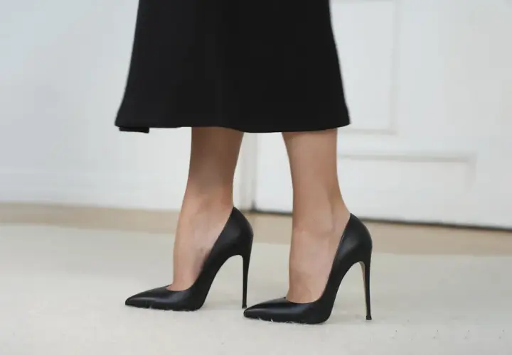 Eleganckie, czarne stopy w szpilkach, podkreślające smukłość nóg.