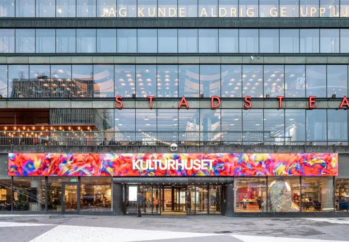 Stockholms kulturhus med en färgstark digital konstinstallation ovanför entrén.