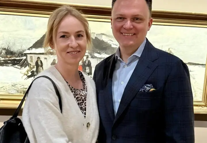 Para uśmiecha się na tle obrazu zimowego pejzażu.