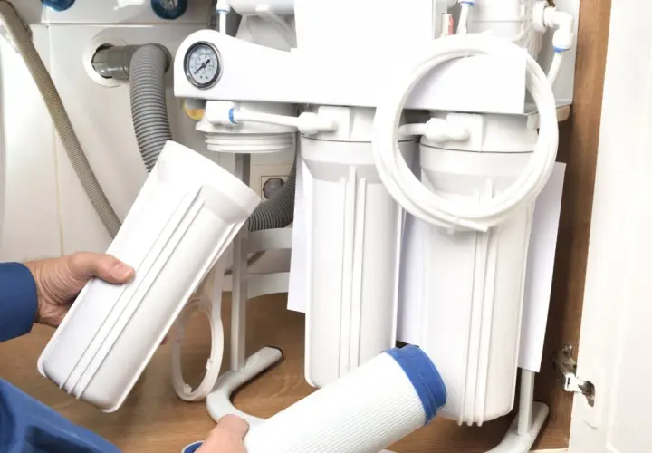 Wymiana filtra sznurkowego do wody: jak często to robić? Ręce trzymają nowe wkłady do systemu filtracji.