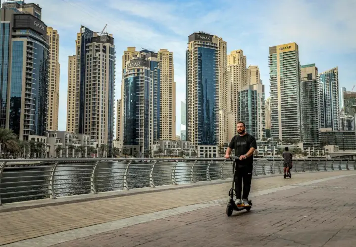 Mężczyzna na hulajnodze w Dubaju, wśród drapaczy chmur. Czy to początek afery dubajskiej?