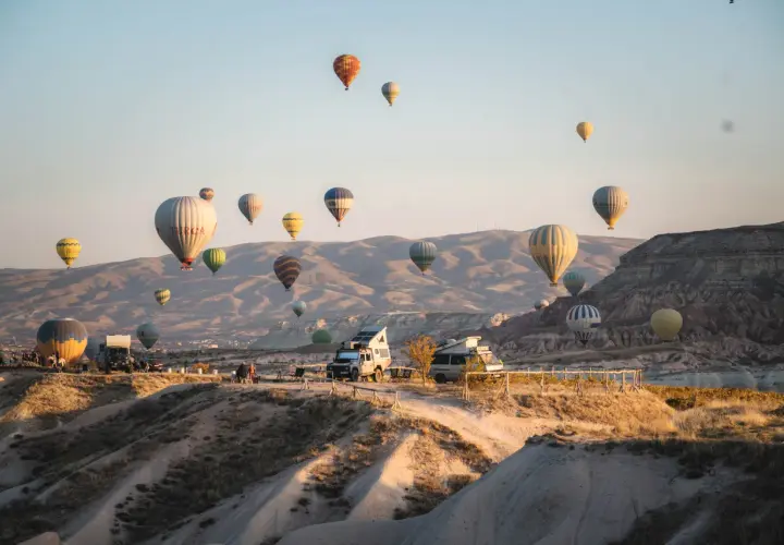 Balony unoszą się nad skalistym krajobrazem Kapadocji w Turcji, tworząc magiczny widok.