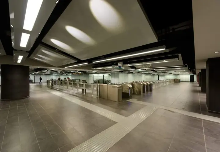 Ingresso moderno della metro Mirti con tornelli e illuminazione a soffitto.