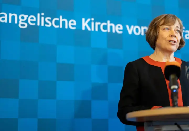 Die EKD-Vorsitzende spricht vor Mikrofonen. Im Hintergrund ist das Logo der Evangelischen Kirche von Westfalen zu sehen.
