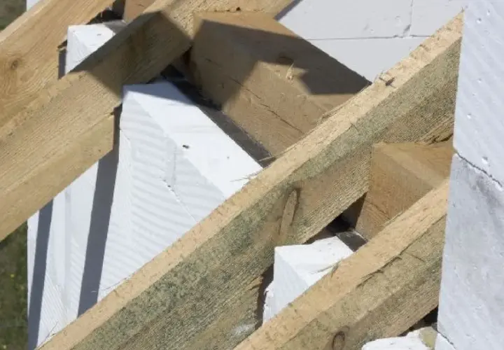 Drewniana konstrukcja dachu, w tym murłata, opiera się na białych bloczkach z betonu komórkowego.