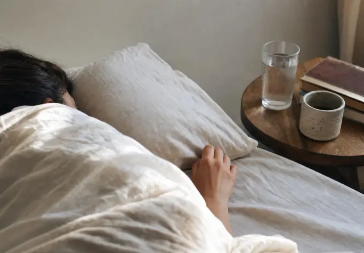 Una persona dorme avvolta nelle lenzuola, forse per sognare una vecchia fiamma. Sul comodino, un bicchiere d'acqua e dei libri.
