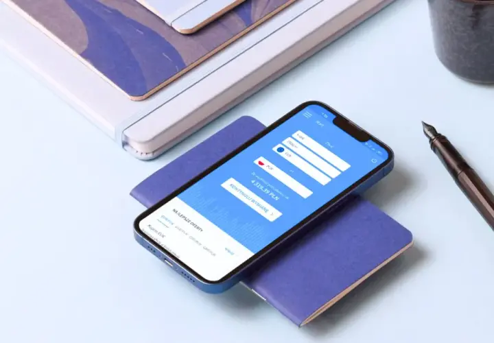 Smartfon z aplikacją do wymiany walut HKD na PLN, obok pióro i notatniki.