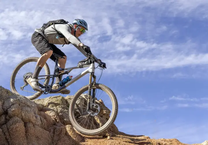 Mountain biker tackling rocky terrain, showcasing the impressive capabilities of the Fox 34 performance review.