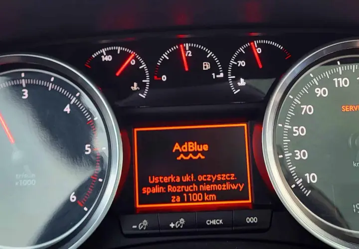 Deska rozdzielcza samochodu Peugeot 508 z wyświetlonym komunikatem o usterce układu oczyszczania spalin i AdBlue.