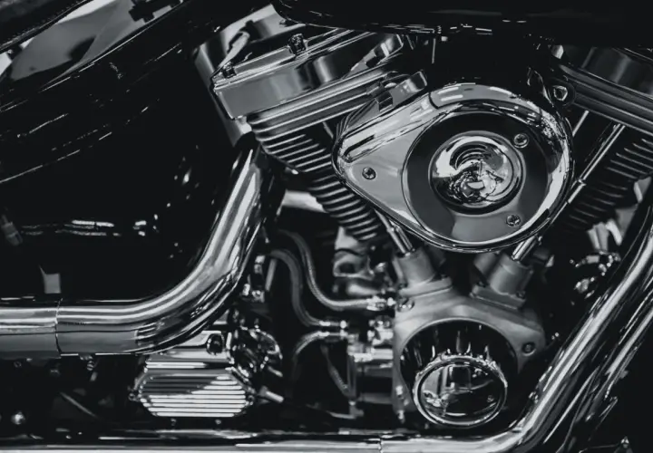 Detalle de un motor de motocicleta cromado, mostrando el sistema de alimentación y sus componentes.