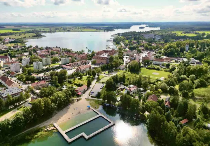Malownicze miasteczko nad jeziorem, z plażą i basenem kąpielowym. Ryn oferuje piękne widoki i relaks.