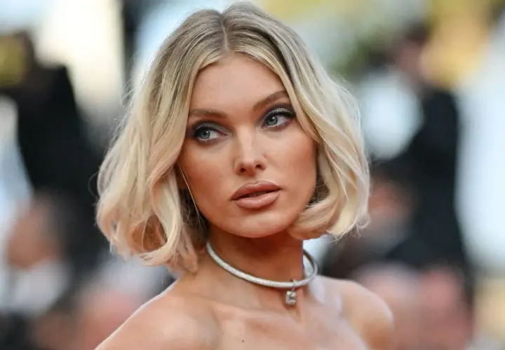 Mujer rubia con un corte de pelo estilo **italian bob**, ojos azules y un collar plateado.