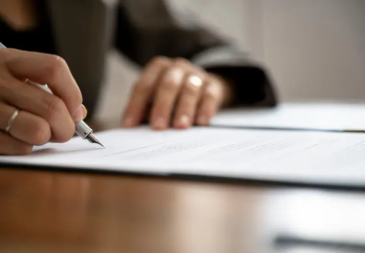 Mano firmando un contrato de arras modelo con pluma estilográfica.
