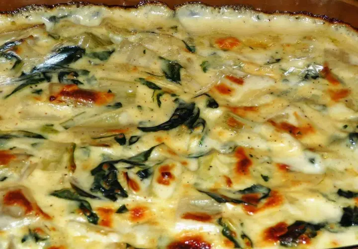 Un gratin crémeux de côte de blette, doré au four, avec des touches de vert et des bords légèrement caramélisés. Un délice réconfortant.