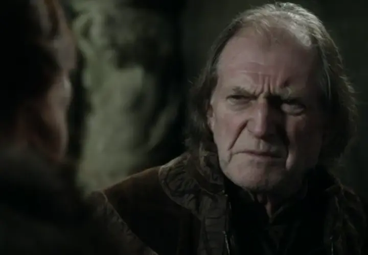 David Bradley w filmach i serialach, z charakterystycznym zmarszczonym czołem, w rozmowie z kimś.