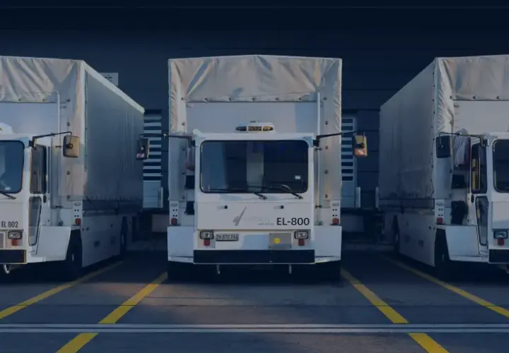 Drei weiße LKW stehen nebeneinander vor einem Gebäude mit der Aufschrift "cargolog". Möglicherweise sind sie von Verkehrsbeschränkungen betroffen.