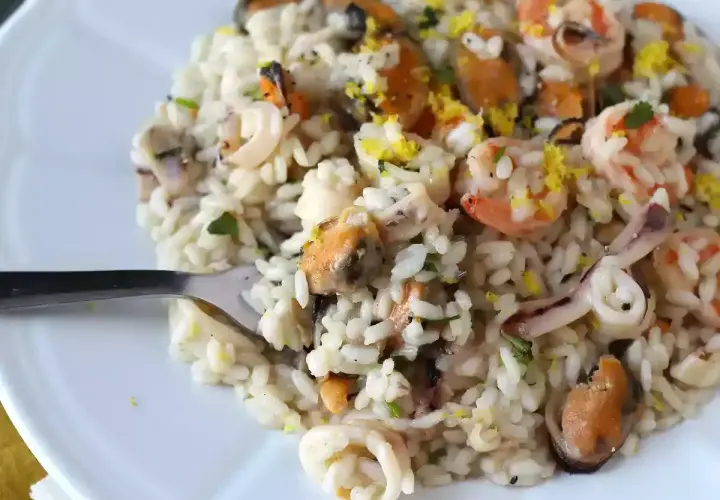 Un délicieux risotto fruits de mer crémeux, garni de crevettes, moules et calamars, avec une touche de zeste de citron.