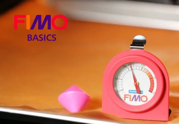 Termómetro FIMO para hornear arcilla. Un trozo de arcilla rosa y un termómetro rojo con la marca FIMO.