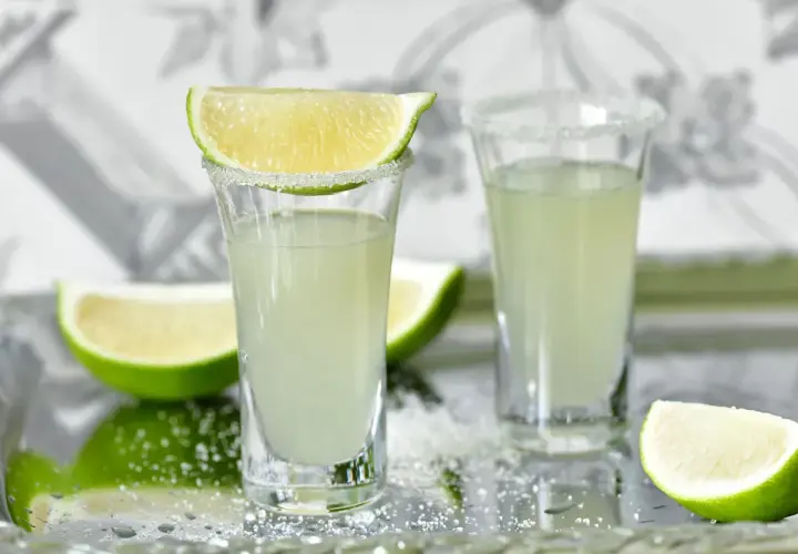 Dwa kieliszki z drinkiem Kamikaze, ozdobione cukrem i limonką. Zastanawiasz się, kamikaze drink ile procent?